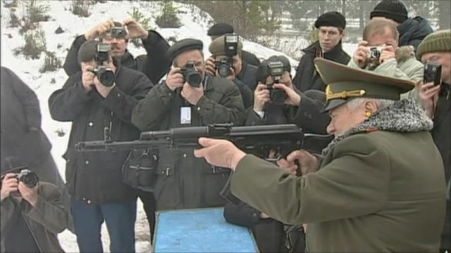 Mikhail Kalashnikov firing with Kalashnikov in front of Media Reporters